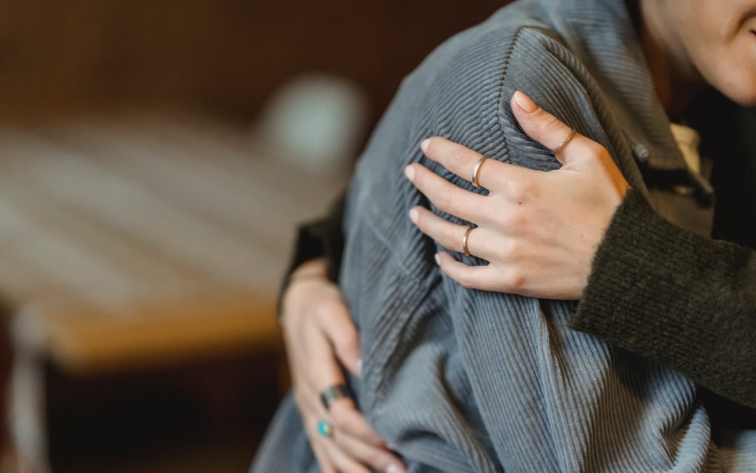 Cropped photo of a person hugging another to show support